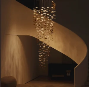 Fluid glass chandelier suspended above luxury villa spiral staircase with warm golden wavy glass pendants