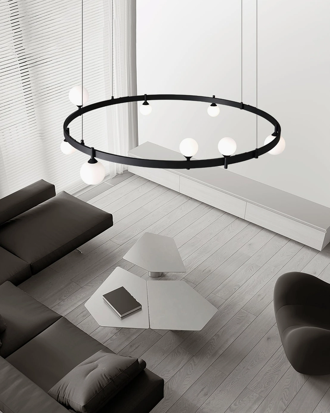 Black circular ring pendant light overhead view in minimalist living room with open floor plan and natural light