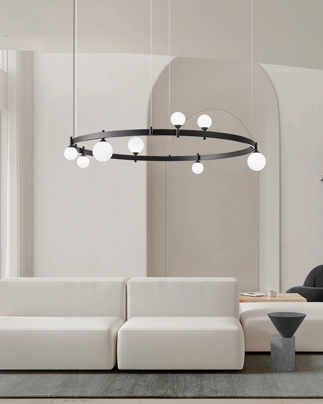 Ring-shaped pendant chandelier three-quarter view in modern living room with low-profile sofa and neutral tones