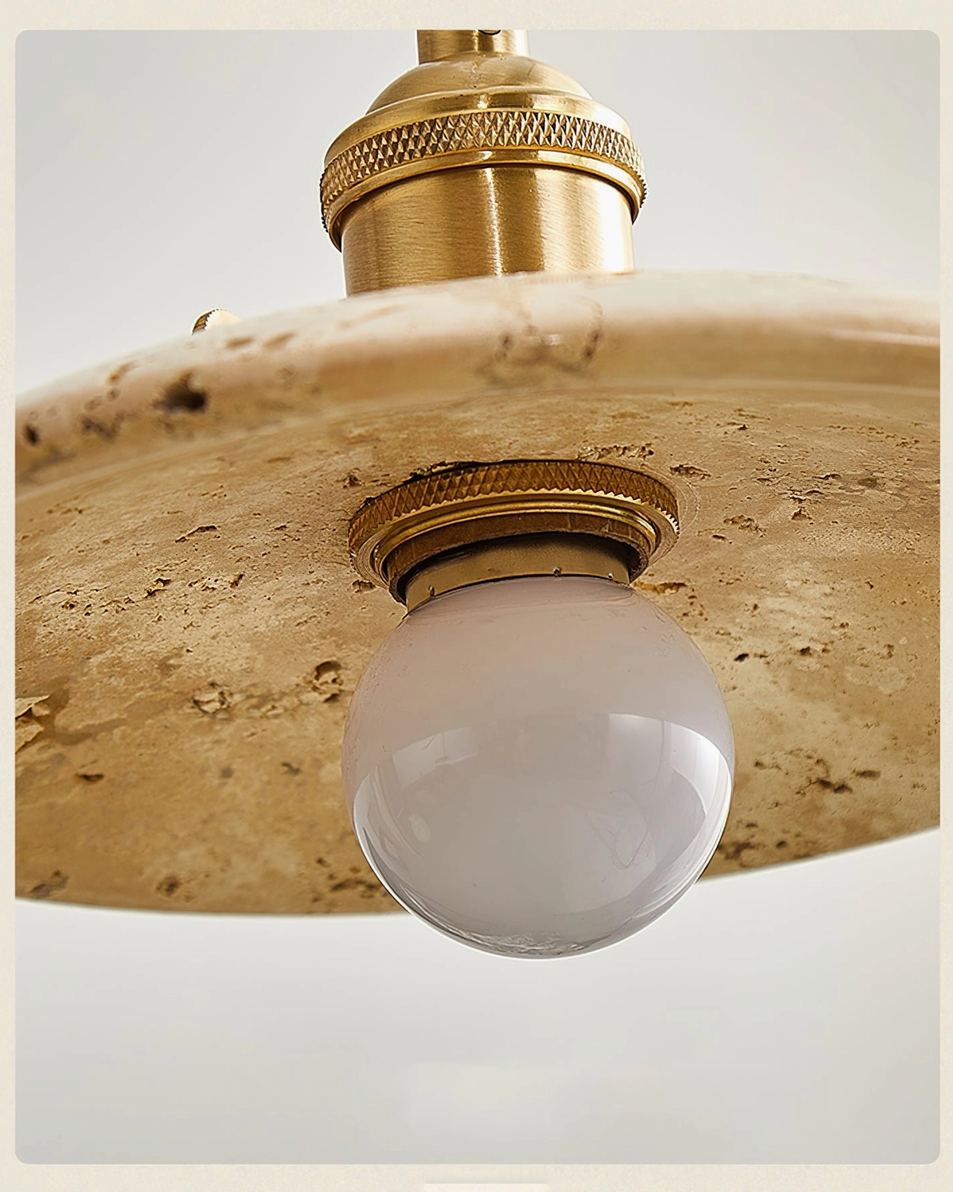 Stella pendant light design with conical travertine shade and brass suspension, ideal for contemporary and transitional interior styling