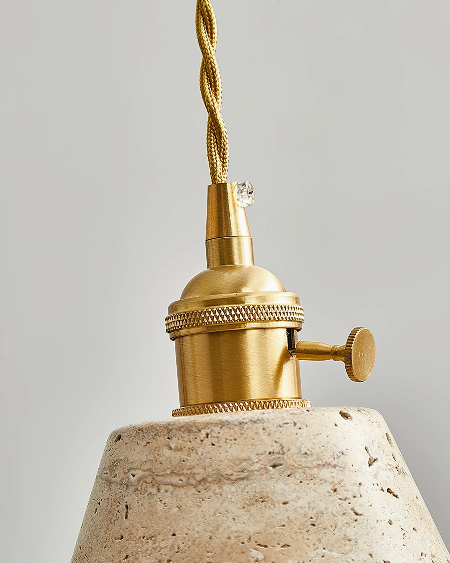 Stella travertine pendant light fixture in modern interior, warm brass and natural stone combination for mid-century modern home décor