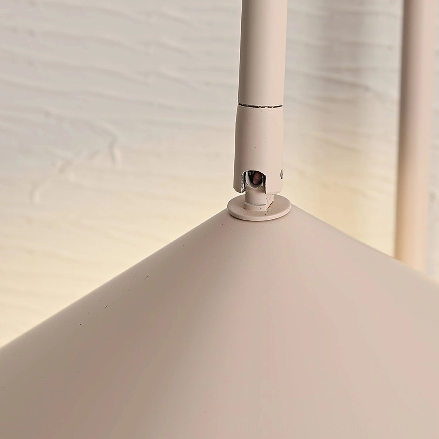 Beige Stella wall lamp detail showing warm neutral finish and matte metal surface texture