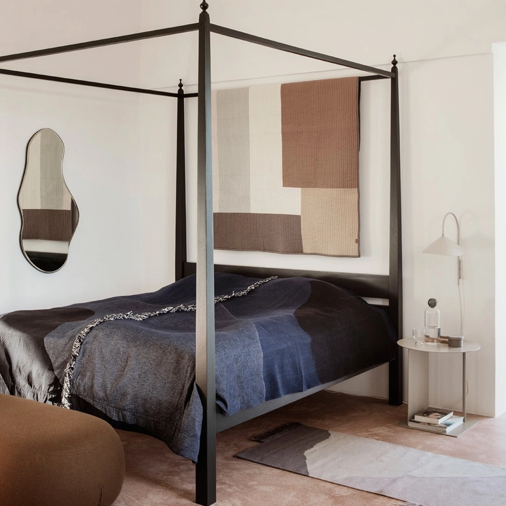 Black Stella wall lamp mounted beside low modern sideboard for sculptural wall presence