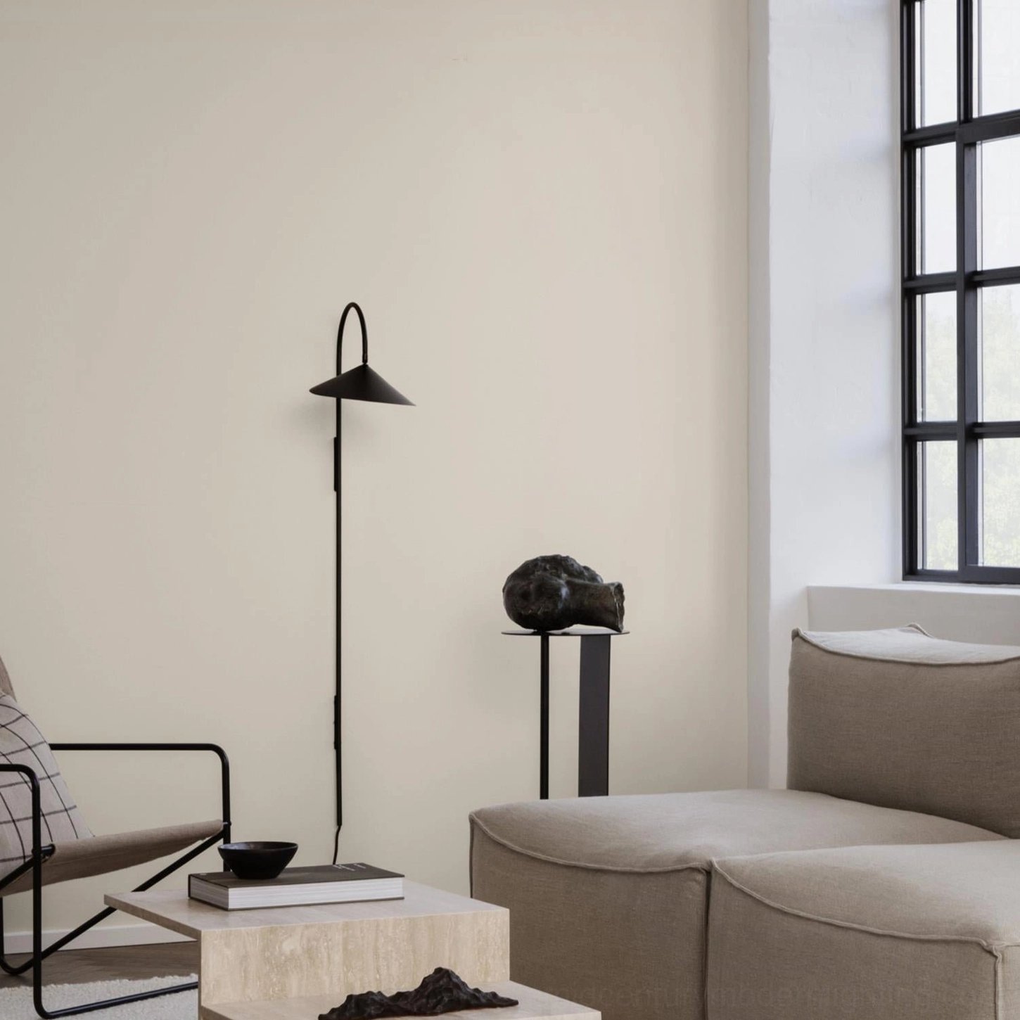 Tall statement Stella wall lamp at 127cm in black positioned in modern living room with neutral decor