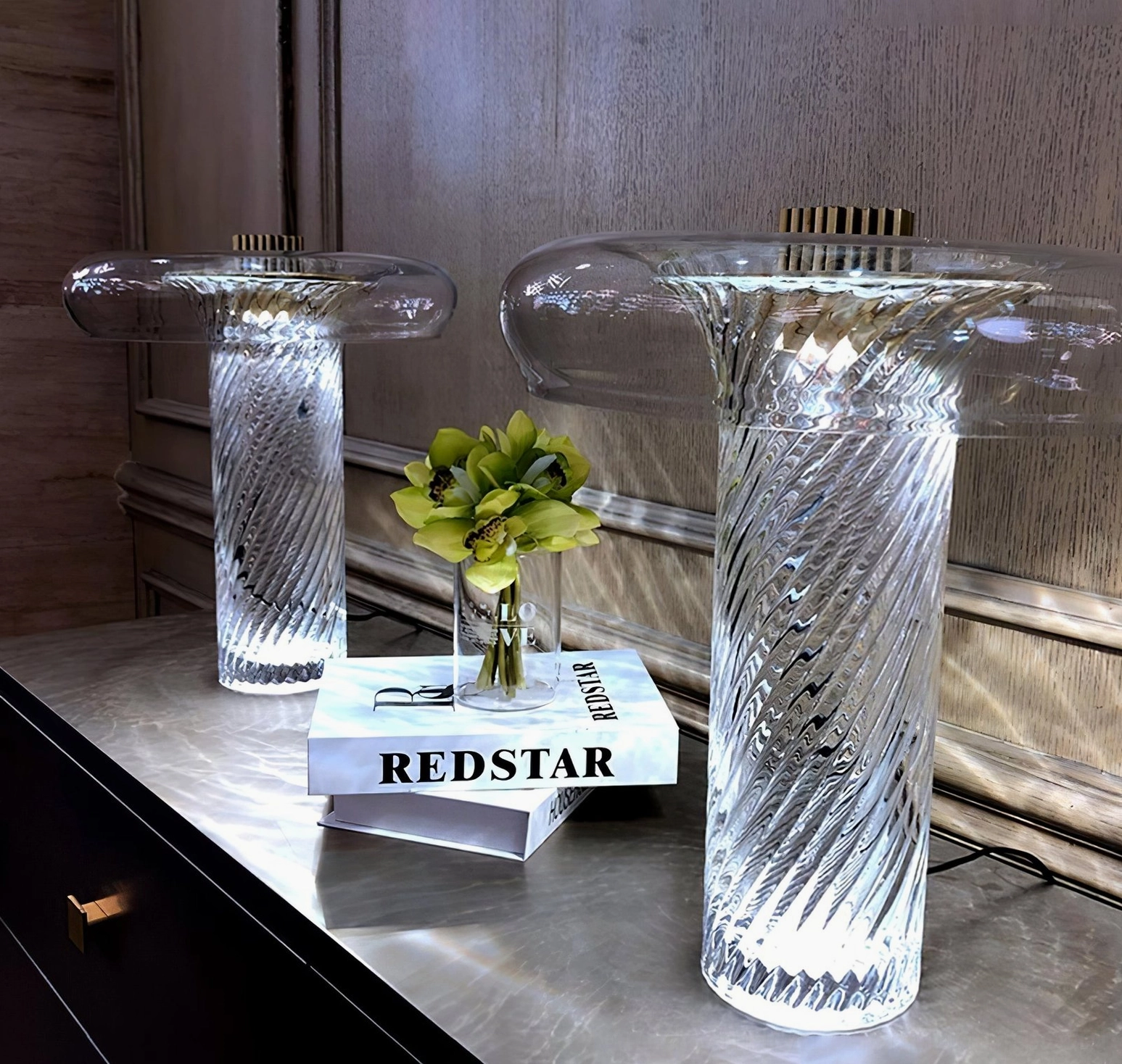 Pair of matching Stellar vintage glass table lamps on luxury bedroom bedside table with books and fresh flowers, warm LED lighting