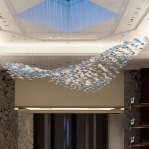 Surge Glass Cloud Chandelier installed in luxury hotel lobby - low upward angle showing integrated LED illumination through suspended glass spheres