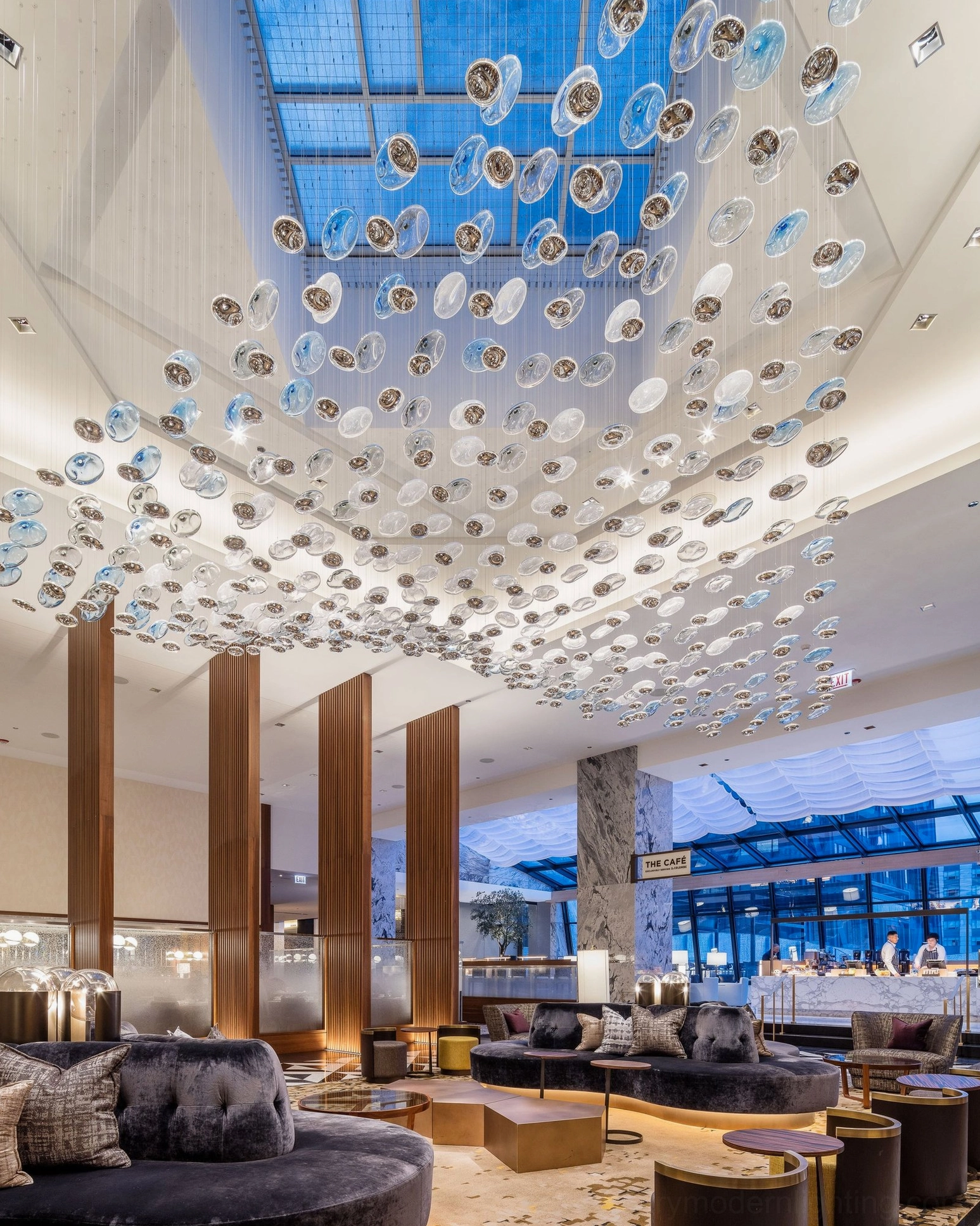 Large scale Surge Glass Cloud Chandelier installation in hotel lobby - upward perspective showing dense wave of suspended glass orbs