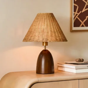 Suri rattan lamp styled on bedroom dresser with warm ambient lighting, decorative books and gallery wall art, three-quarter perspective