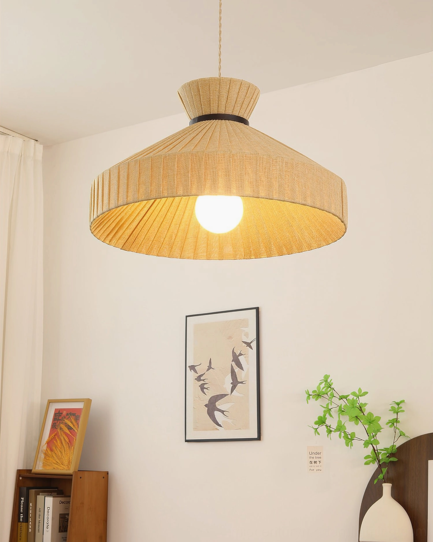 Surora pendant light suspended above bookshelf creating warm glow, cozy room ambiance with lit bulb visible