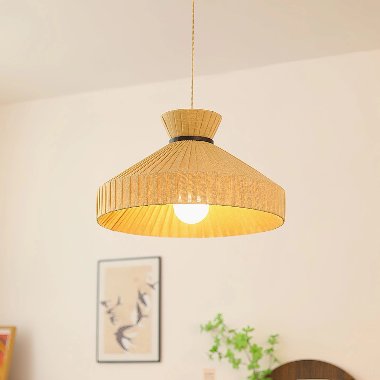 Surora pendant light glowing above bird artwork and indoor wall decor, warm incandescent bulb creating cozy atmosphere