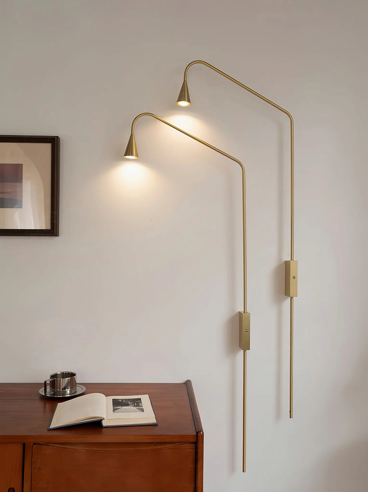 Pair of matching brass gold Svarna wall sconces flanking bed, contemporary bedroom nightstand lighting setup