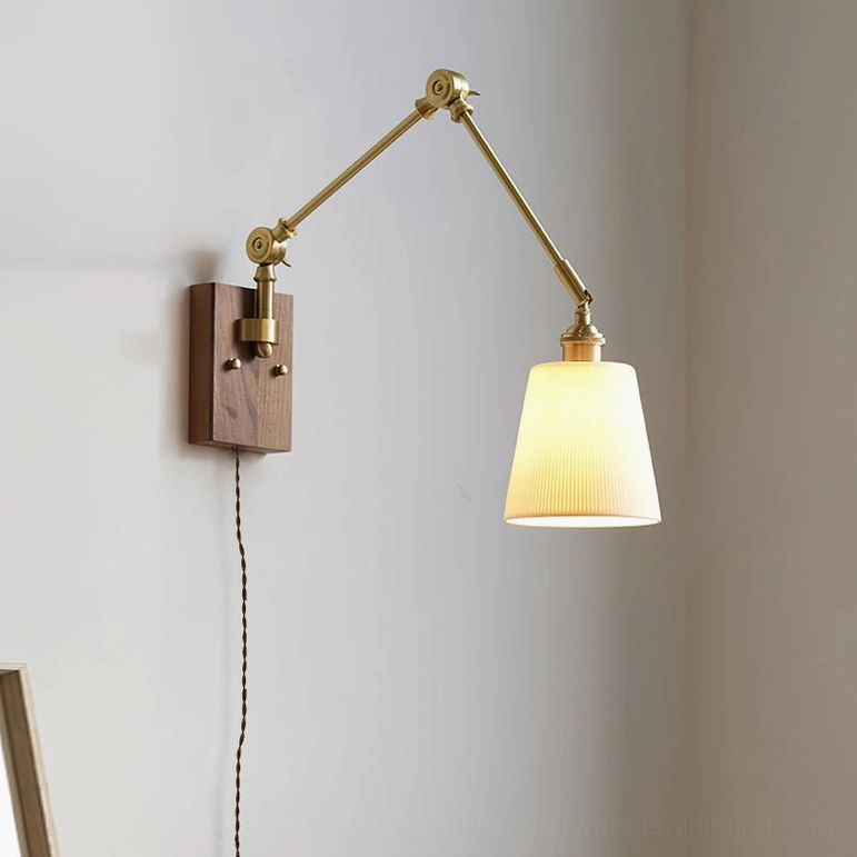 Compact swing arm ceramic wall lamp with brass swing mechanism and walnut wood mounting