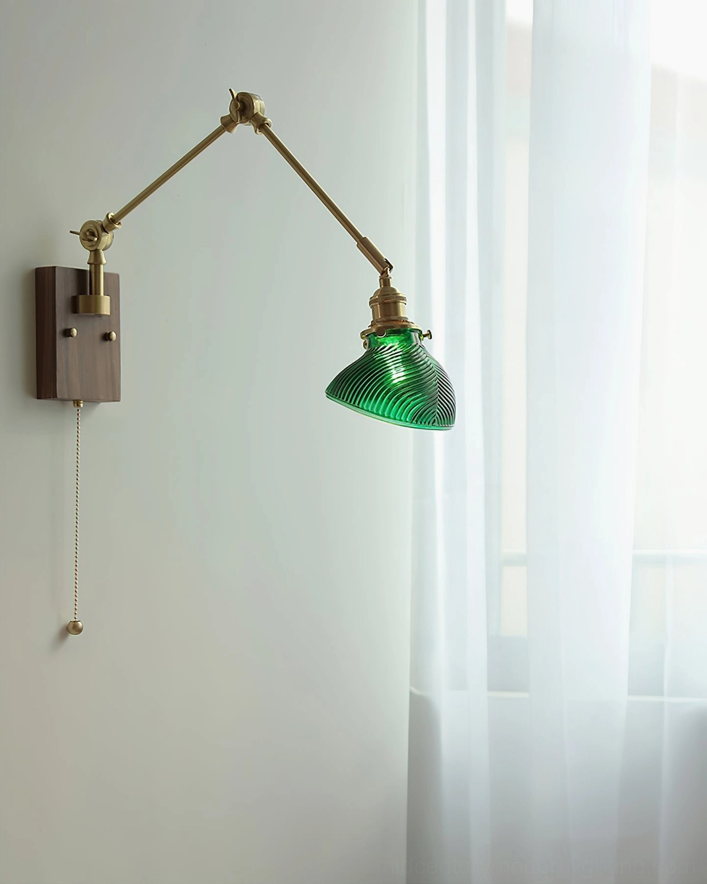 Close-up side view of brass swing arm mechanism and ribbed glass shade detail on mid-century modern wall lamp