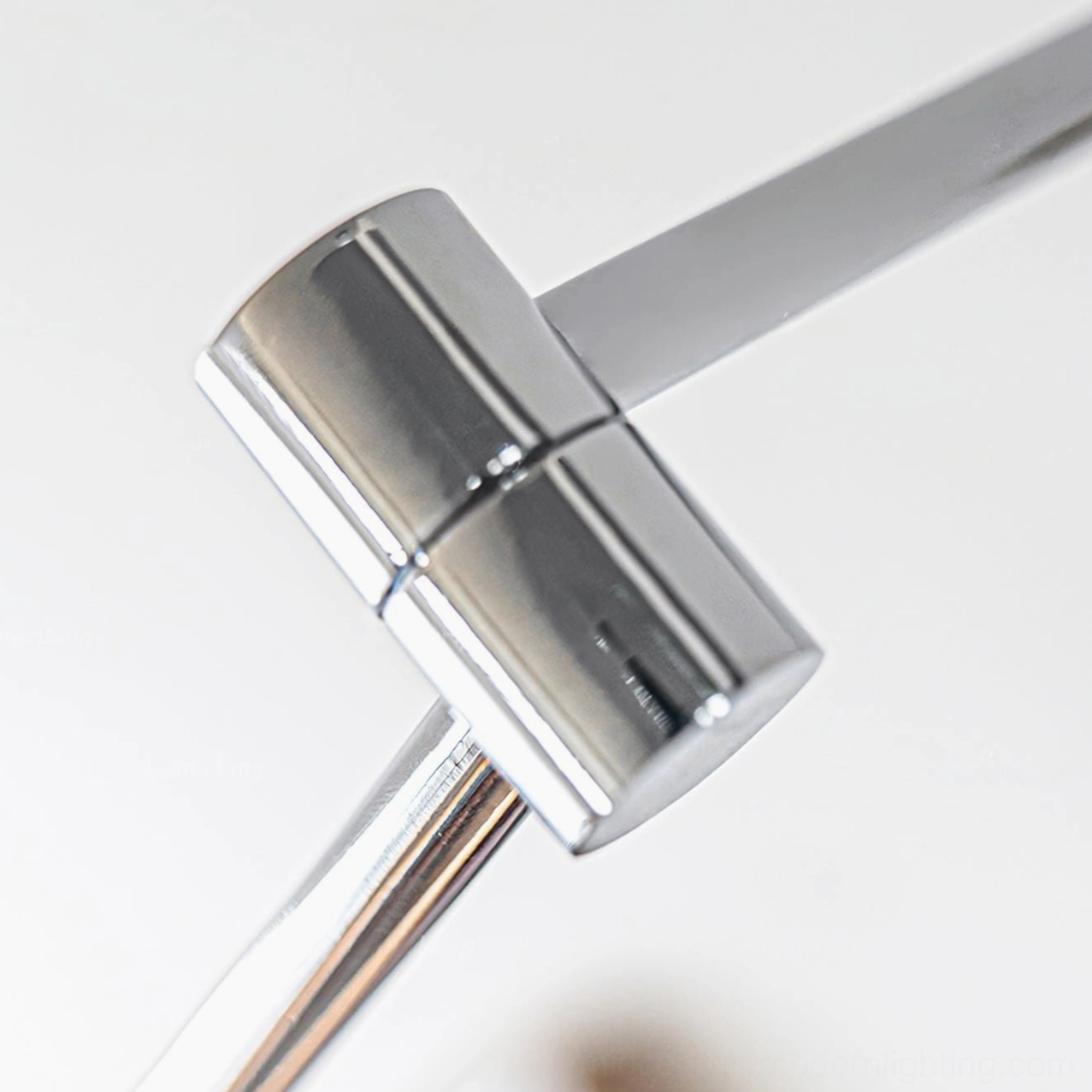 Side macro close-up of swing arm lamp's polished chrome swivel joint featuring mid-century modern hardware styling