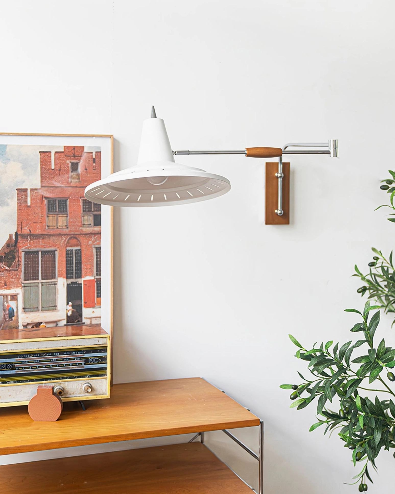 Close-up detail of swing arm wall lamp showing white conical shade with ventilation slits, chrome arm and wooden wall mount