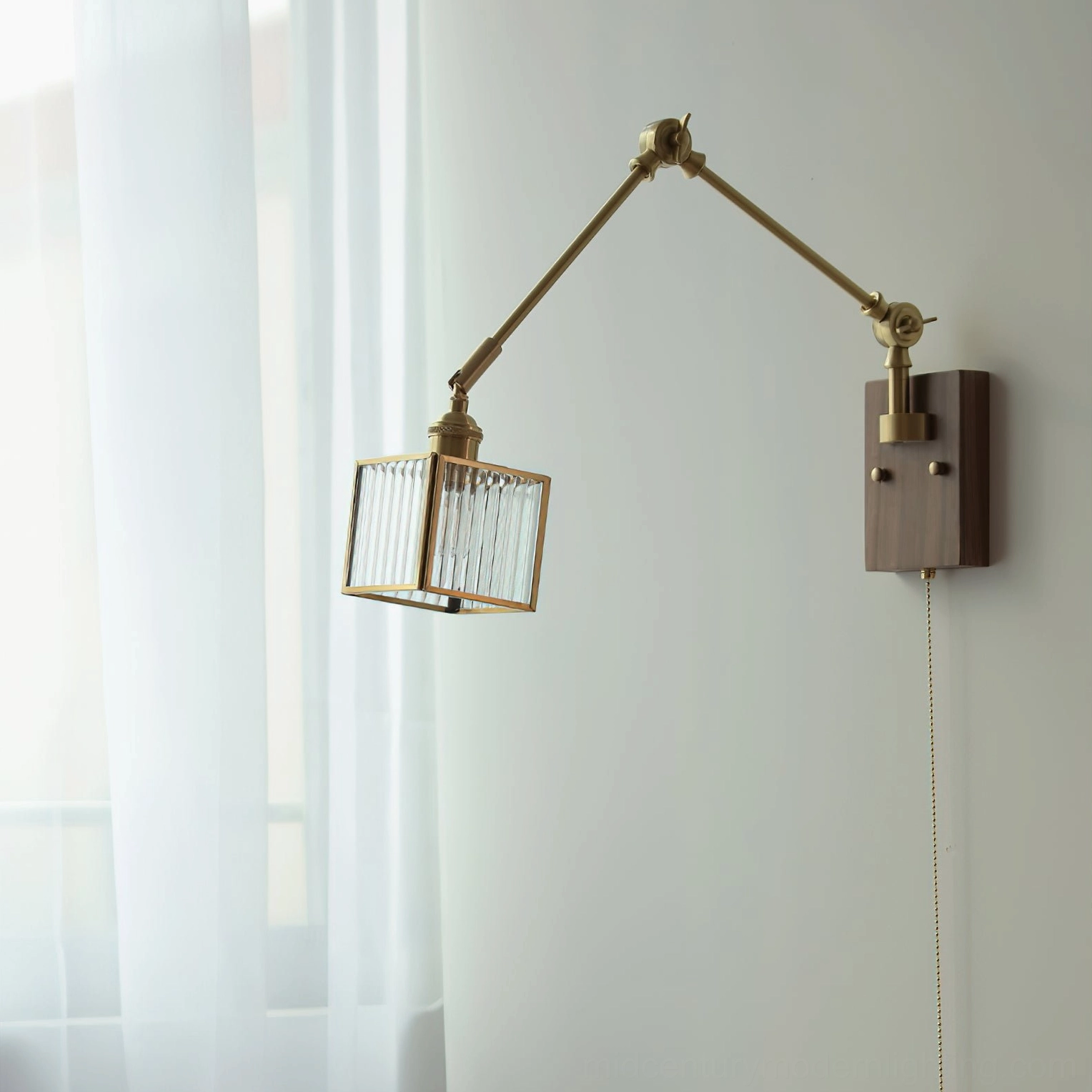 Detail view of swing arm wall lamp showing brass joints, dark wood base, and textured glass shade with pull-chain control