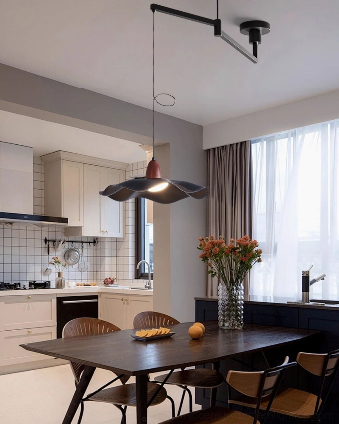 Warm sculptural pendant light above dark wooden dining set in natural light minimalist kitchen-dining room