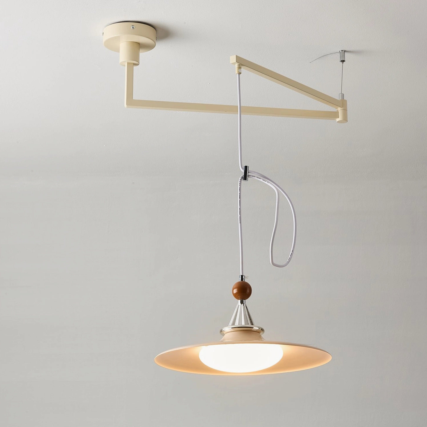 Eden swing arm pendant light architectural detail showing chrome hardware and green spherical accent cap design element