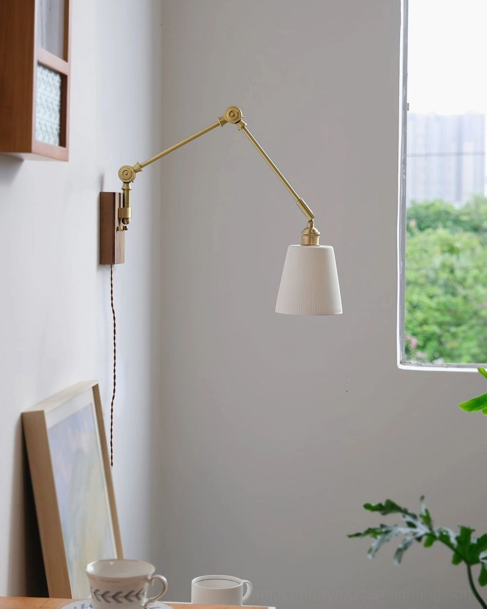 Plug-in swing arm wall lamp with brass arm and off-white conical shade on neutral wall