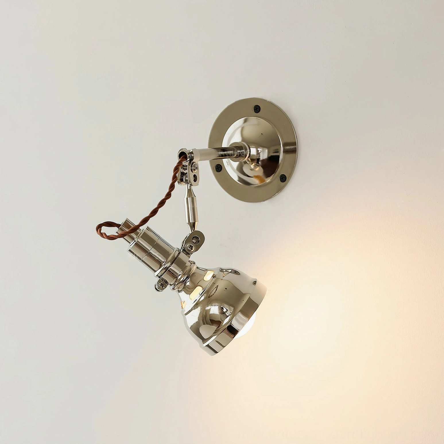 Swing arm wall sconce detail shot showing adjustable mechanism and polished chrome surface finish