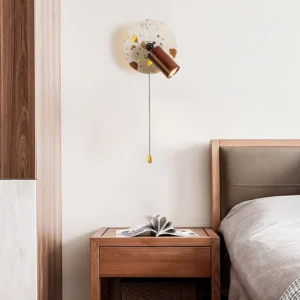 Swizzle wall lamp bedroom installation beside wooden nightstand providing warm ambient lighting in modern minimalist bedroom setting