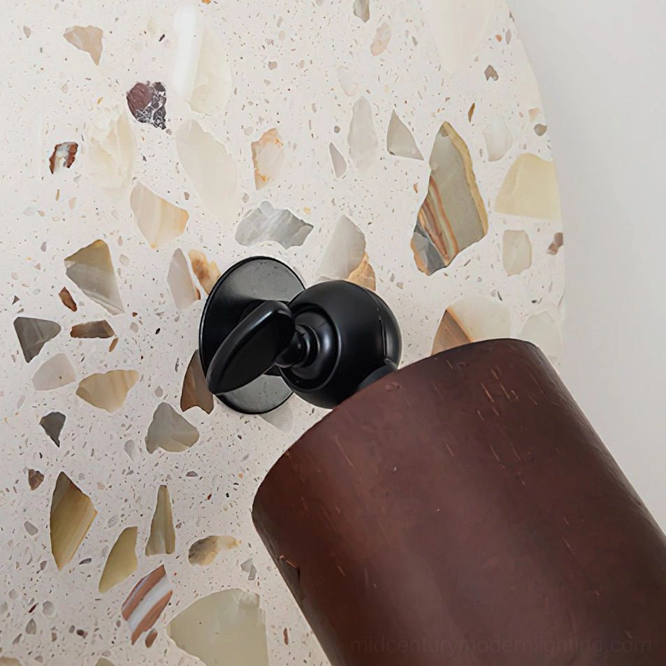Swizzle wall lamp architectural detail showing terrazzo stone construction with unique amber fragment pattern and sophisticated walnut wood frame