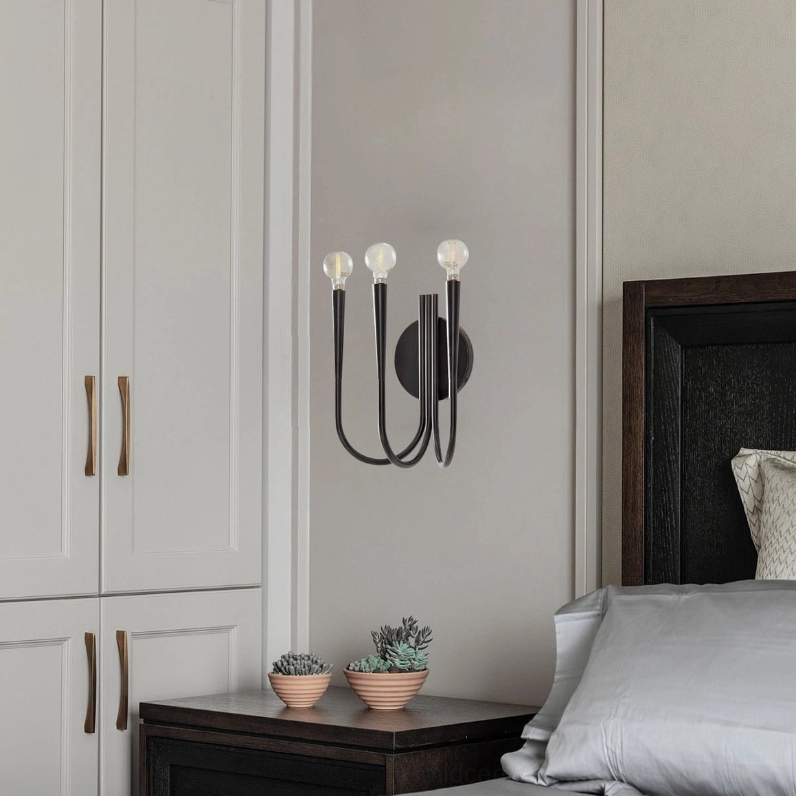 Matte black Swoop wall sconce illuminating bedroom bedside area with minimalist dark aesthetic accent lighting