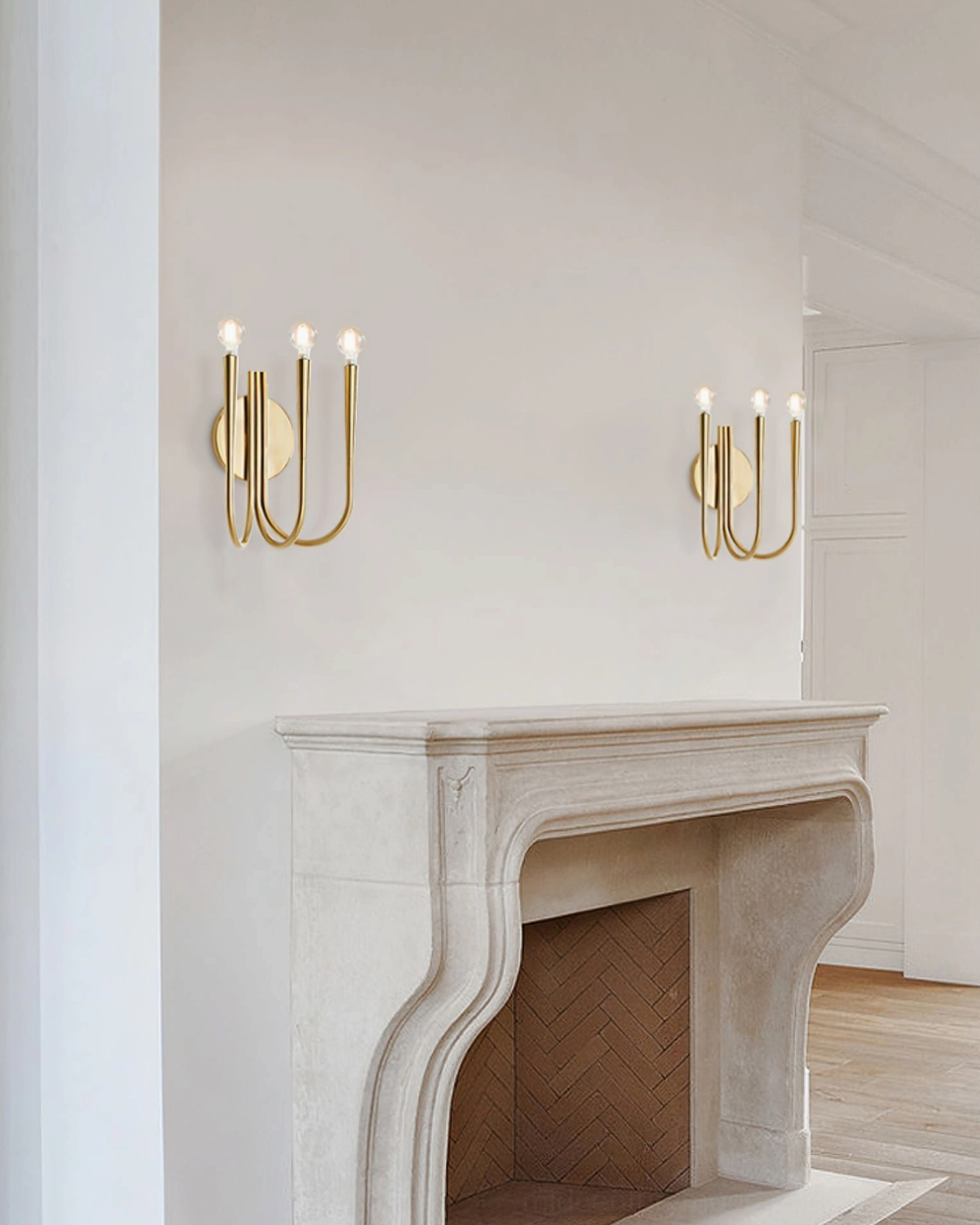 Matching pair of Swoop brass wall sconces symmetrically arranged above marble fireplace in modern living room