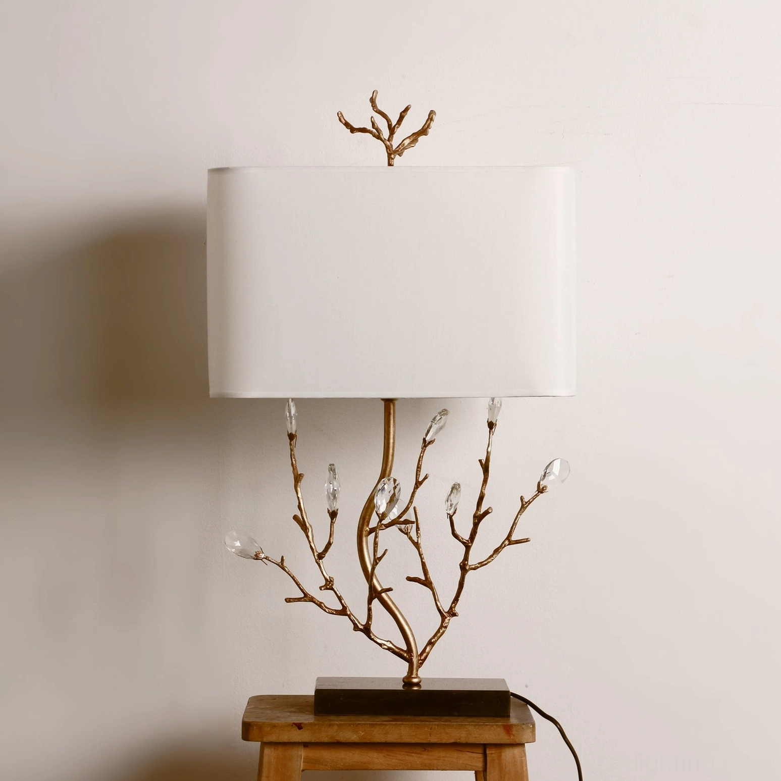 Sylvia branch table lamp side angle view unlit, showing sculptural brass form against neutral wall backdrop