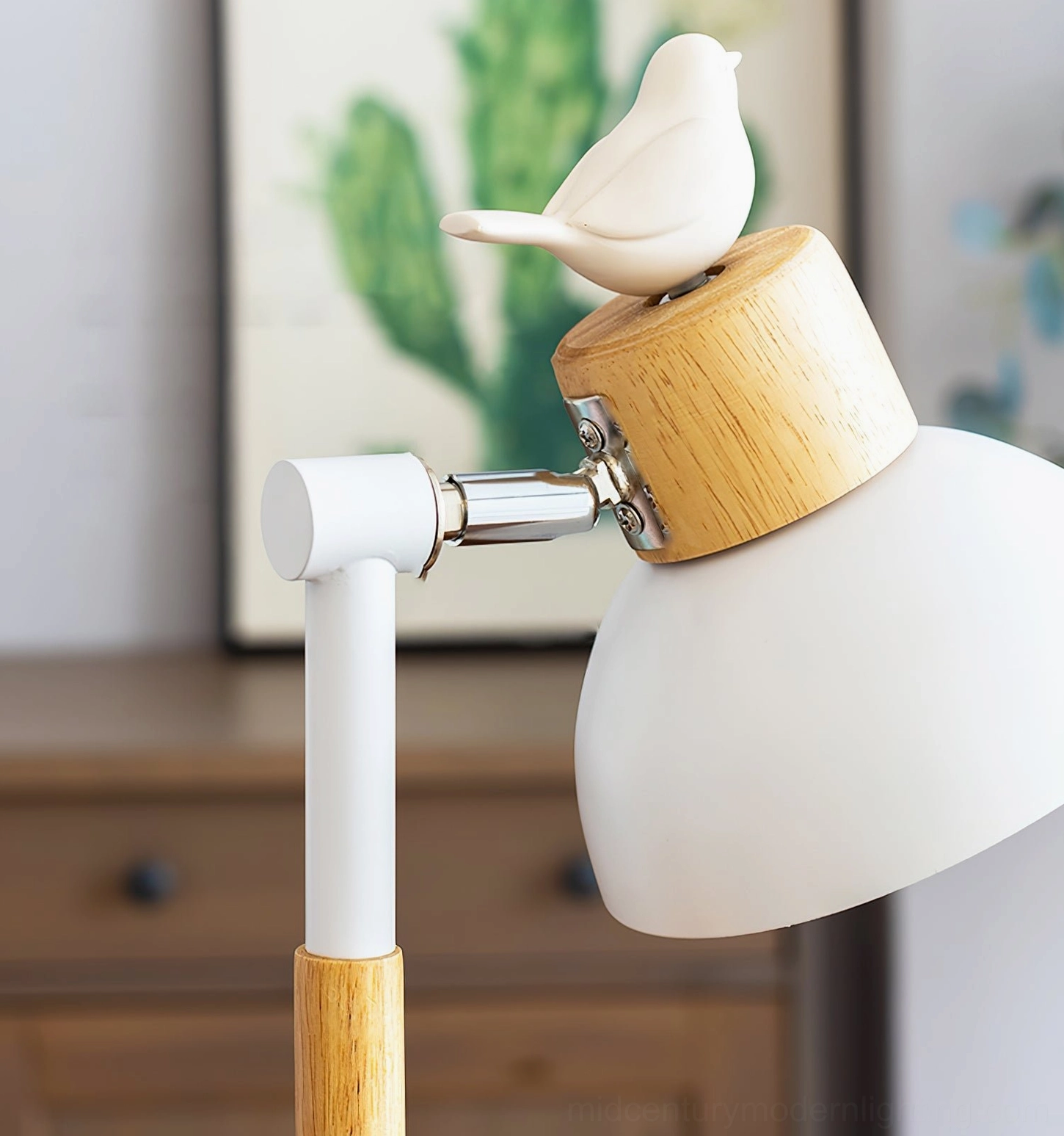 Close-up detail of adjustable metal lamp head joint with wooden accent and cactus wall art background
