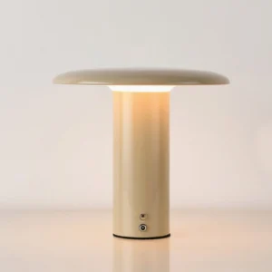 Takku warm beige gray LED task lamp illuminated on desktop showing touch control base and warm light output