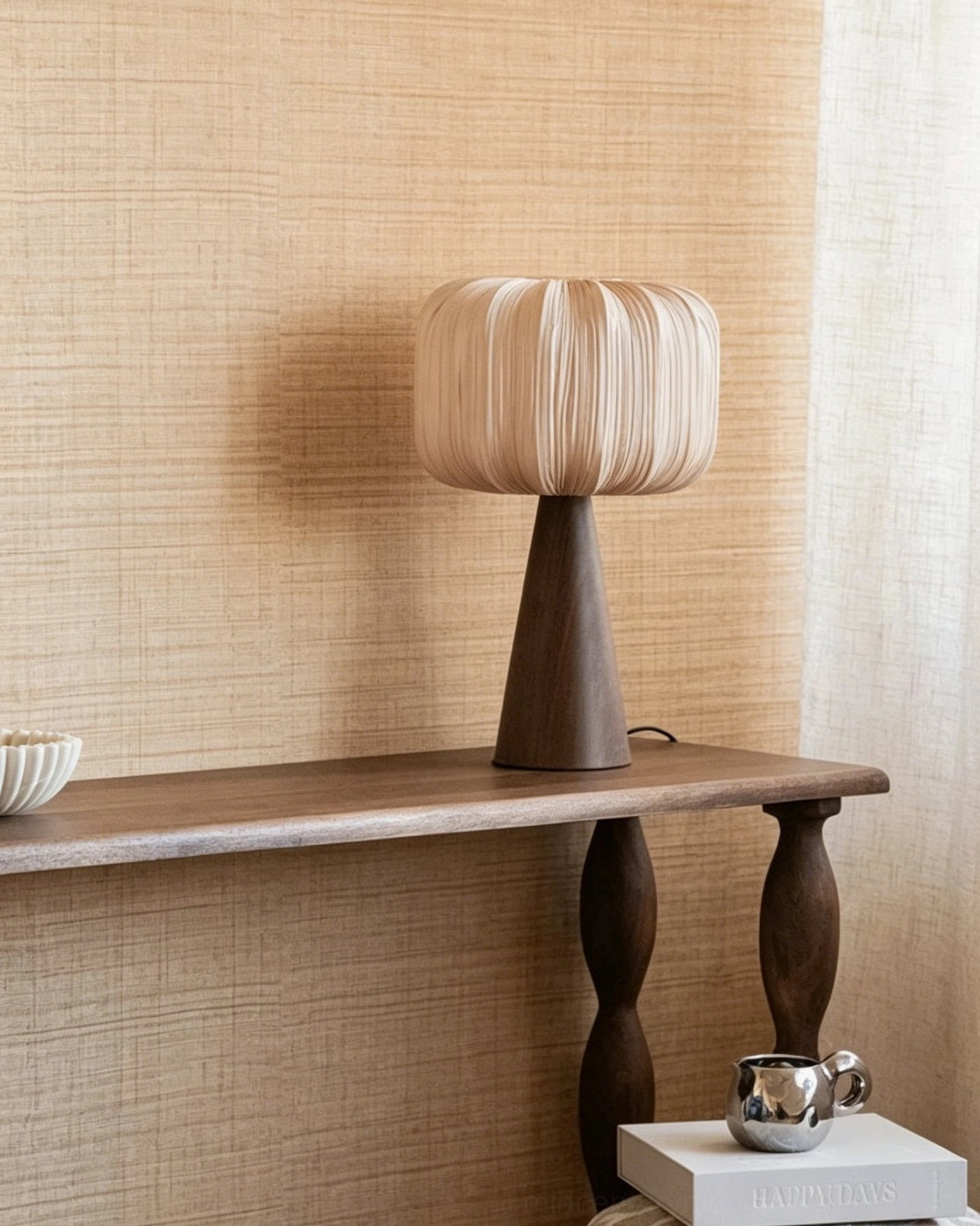 Talia pleated table lamp side profile on wooden console with small ornaments showing organic design and warm beige shade