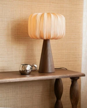 Talia table lamp three-quarter view styled on wooden console table with metal decorative accessories in modern interior setting