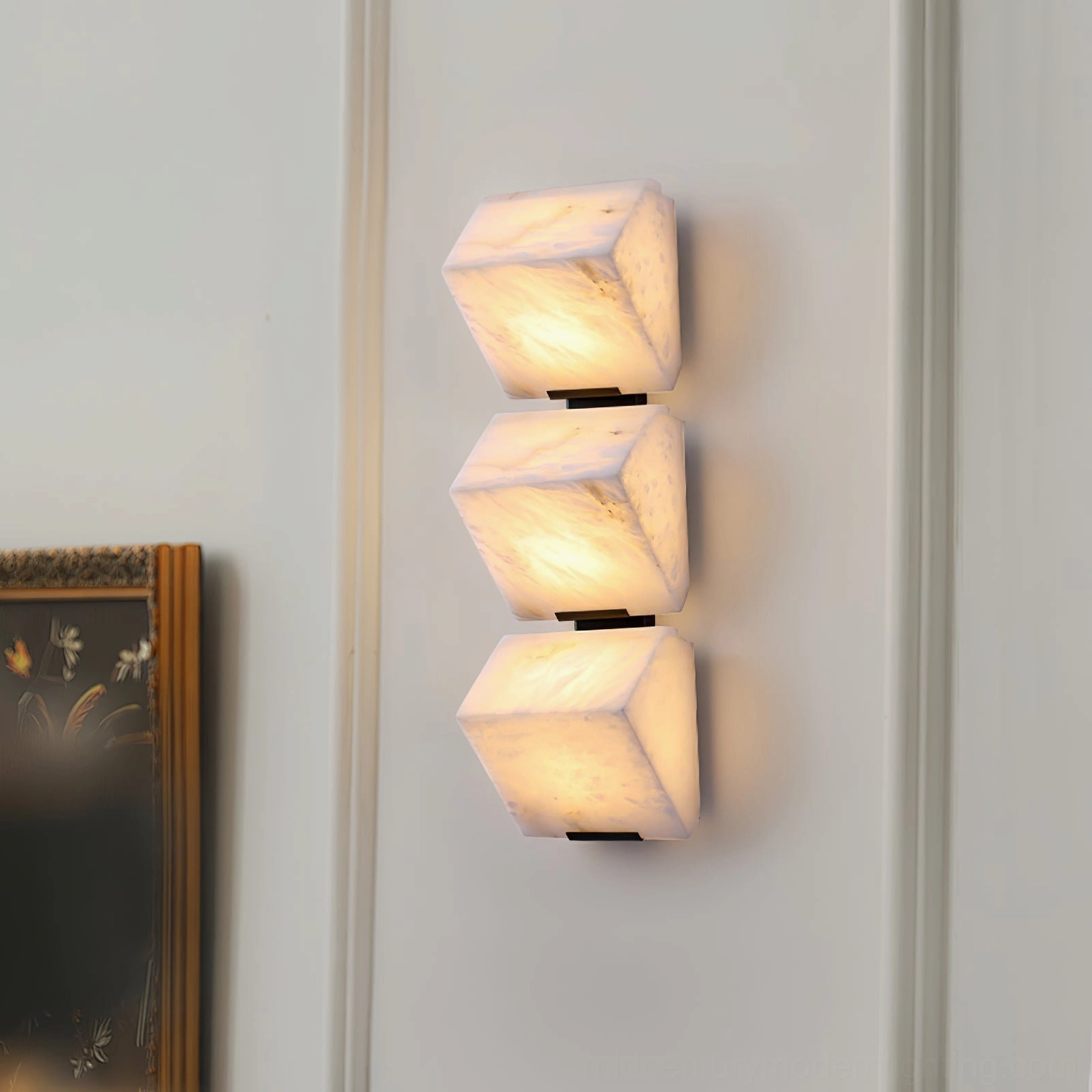 Vertical three-light alabaster wall lamp showing stacked cubic alabaster shades with warm ambient glow in residential interior