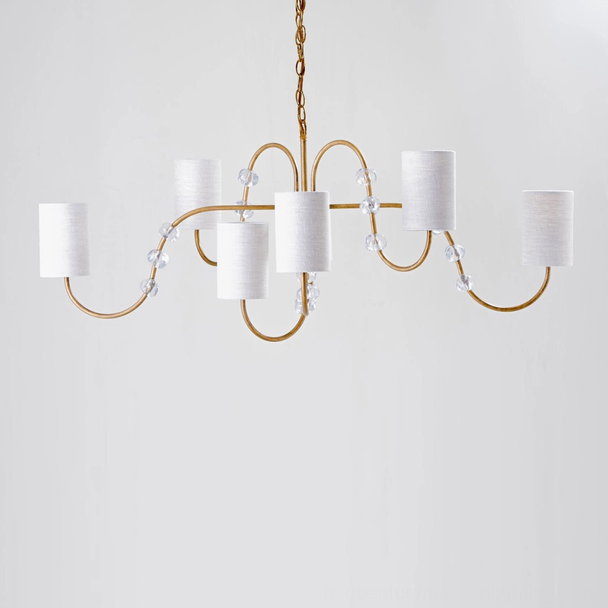 Tanyel chandelier elegant brass curved arms with crystal bead details and white cylinder fabric shades studio photograph