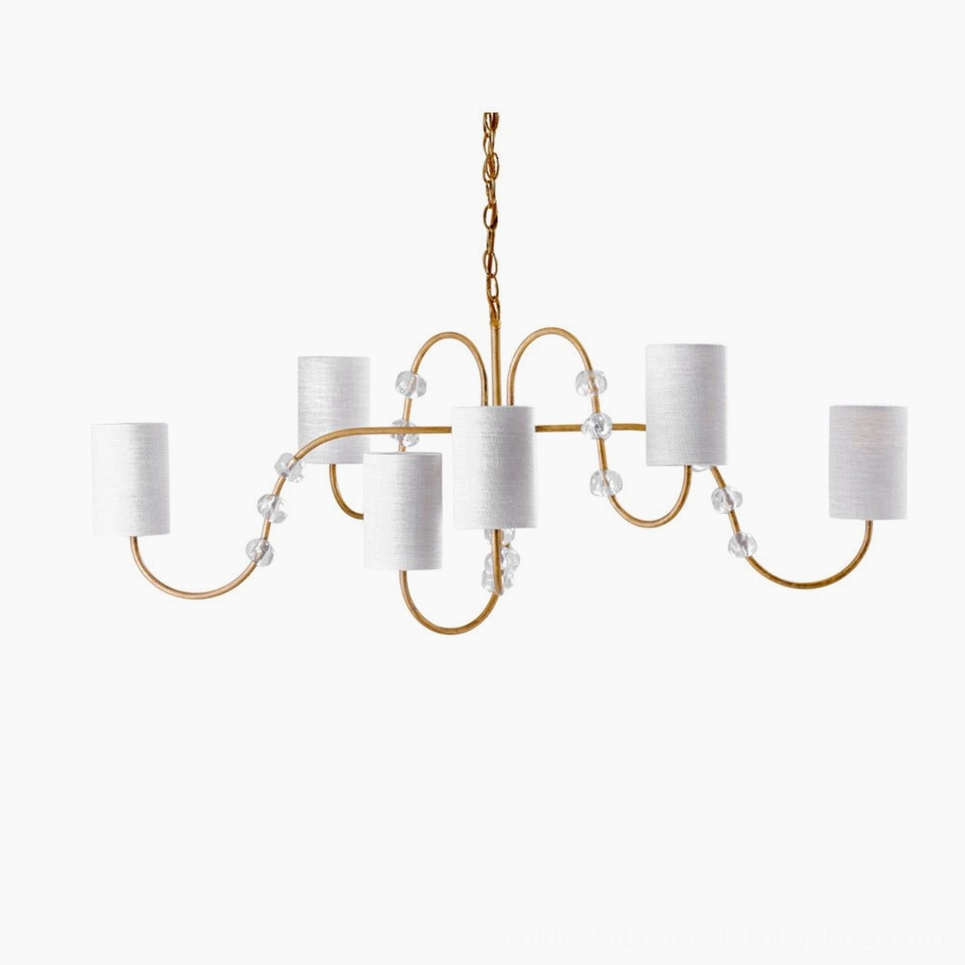 Tanyel six-light mid-century modern chandelier with curved brass arms, crystal bead accents, and white fabric drum shades frontal view