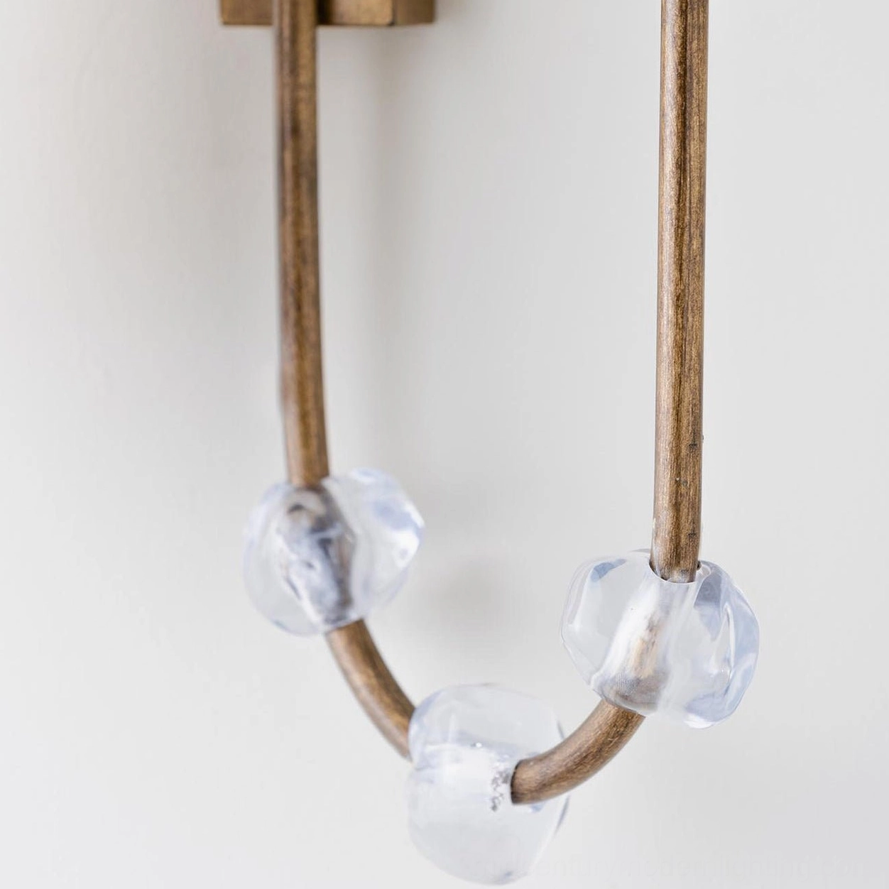 Close-up detail of Tanyel sconce showing faceted crystal glass beads and curved brass rod mechanism