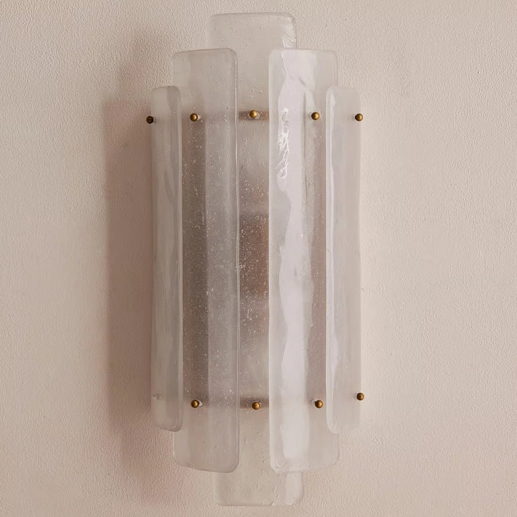 Close-up side angle of Tasha seeded glass sconce showing thick layered Art Deco texture and brass details