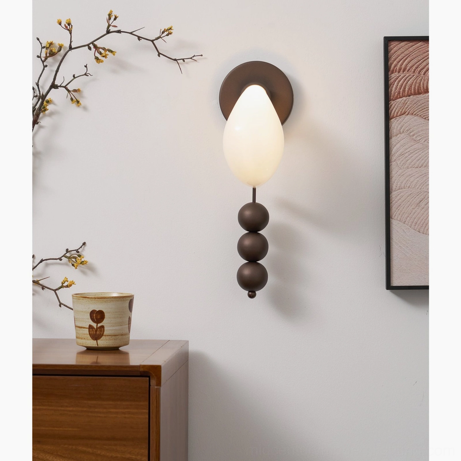 Teardrop glass wall lighting fixture with three sculptural spheres and dark bronze base, architectural wall mounting detail