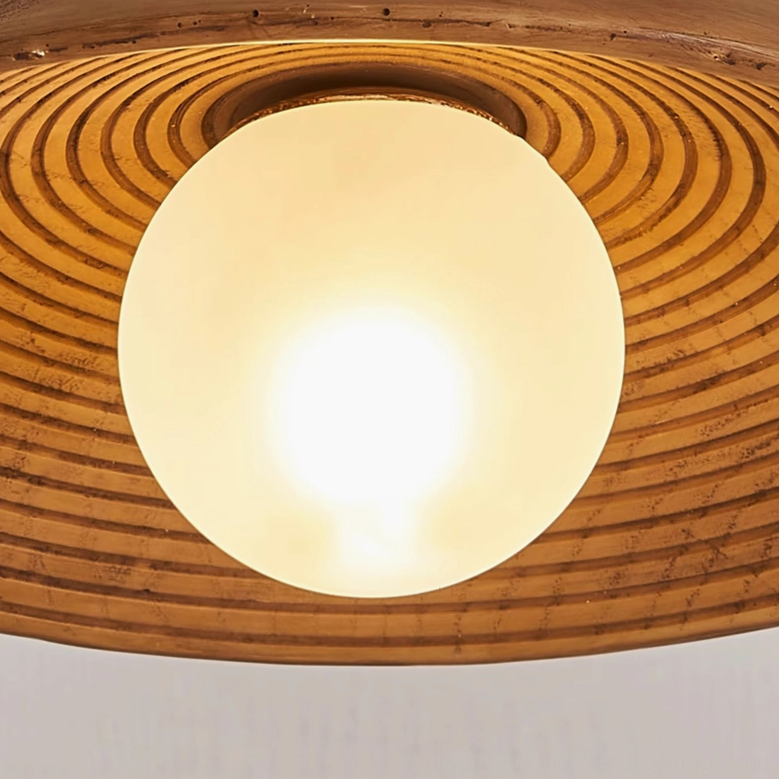 Teelin ceiling light close-up detail view showing concentric wood grain and frosted sphere bulb