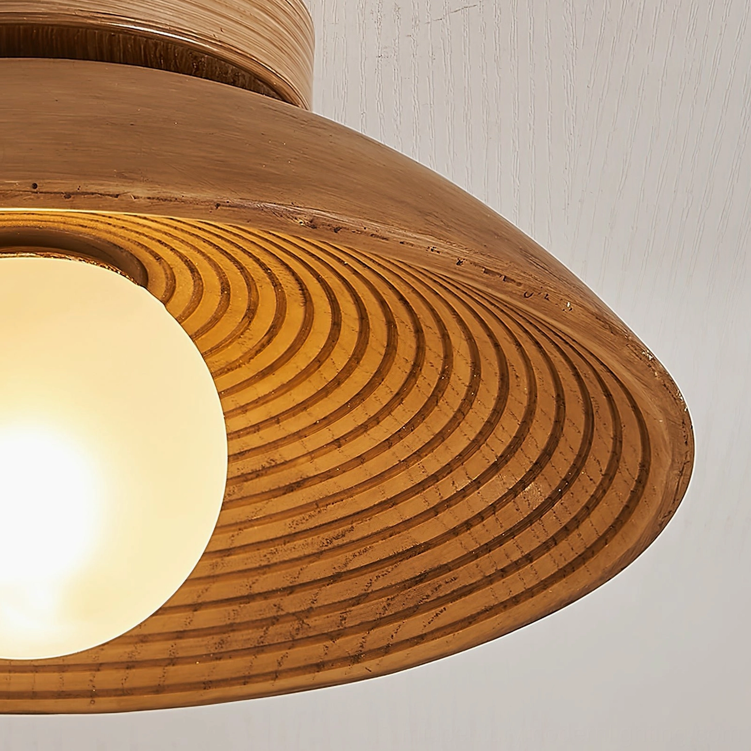 Teelin ribbed wood ceiling fixture side angle view with warm frosted bulb illumination