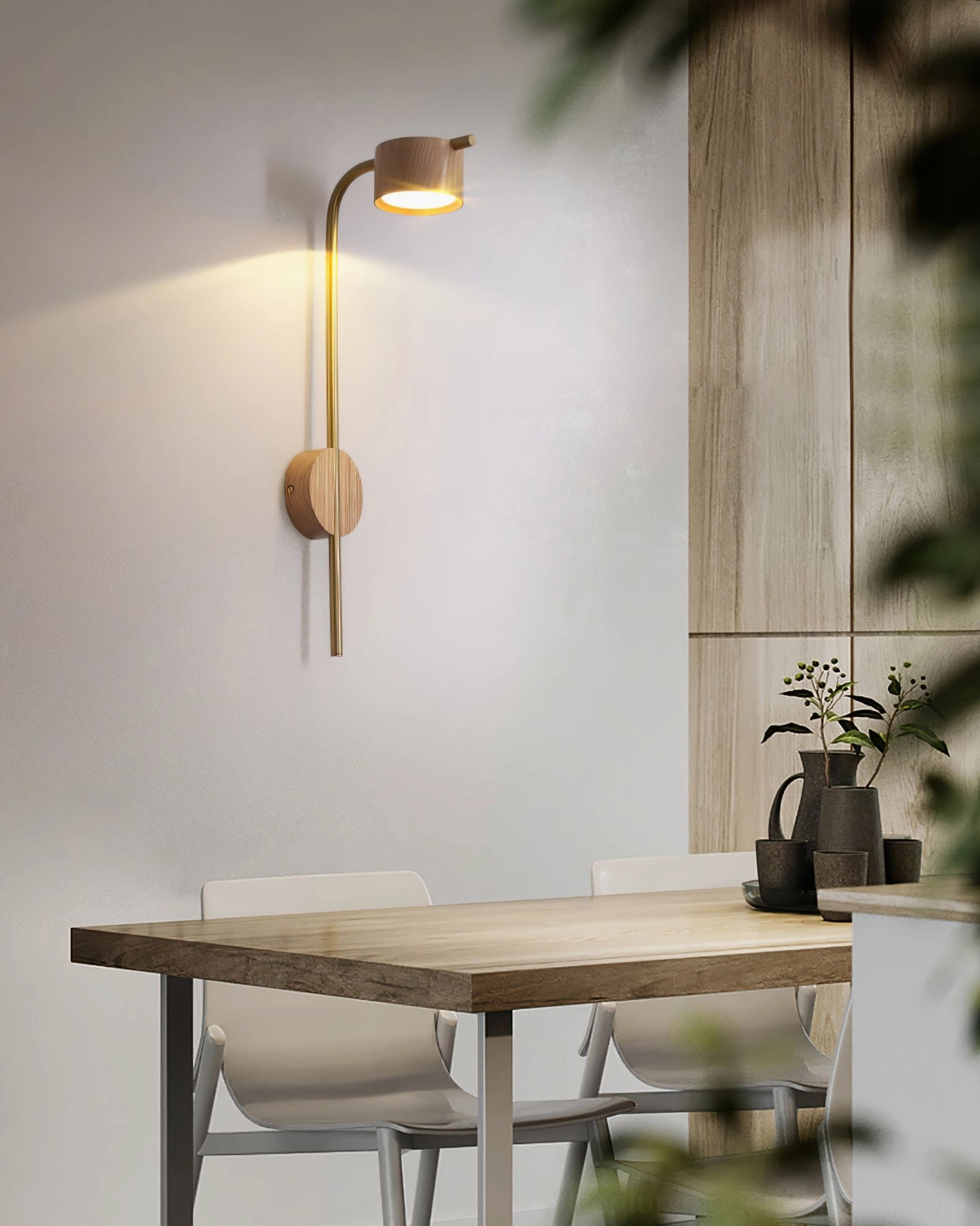 Arched brass wall sconce mounted in contemporary dining space above wooden table
