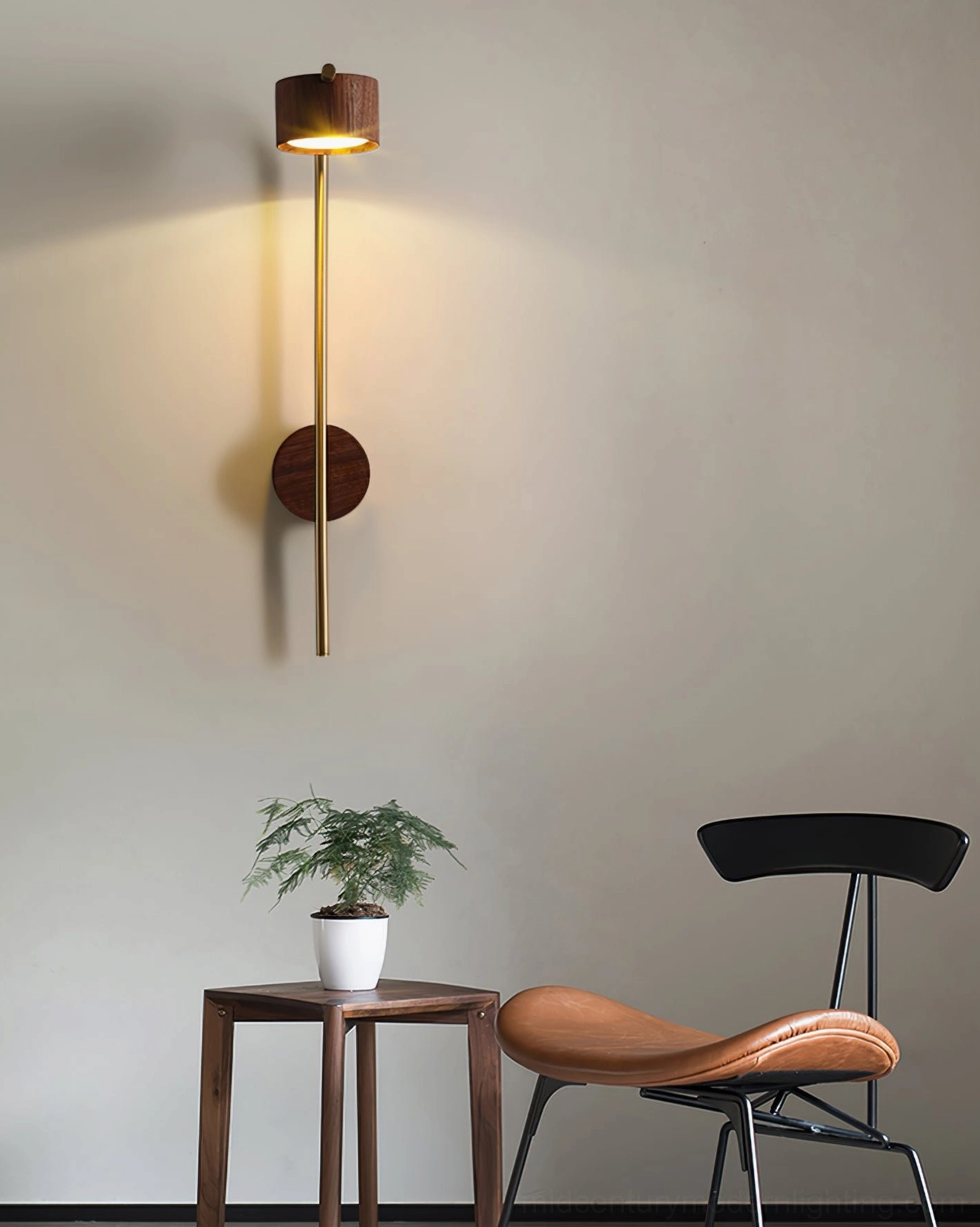 Minimalist wall-mounted reading light with tall brass arch in modern lounge area with leather chair