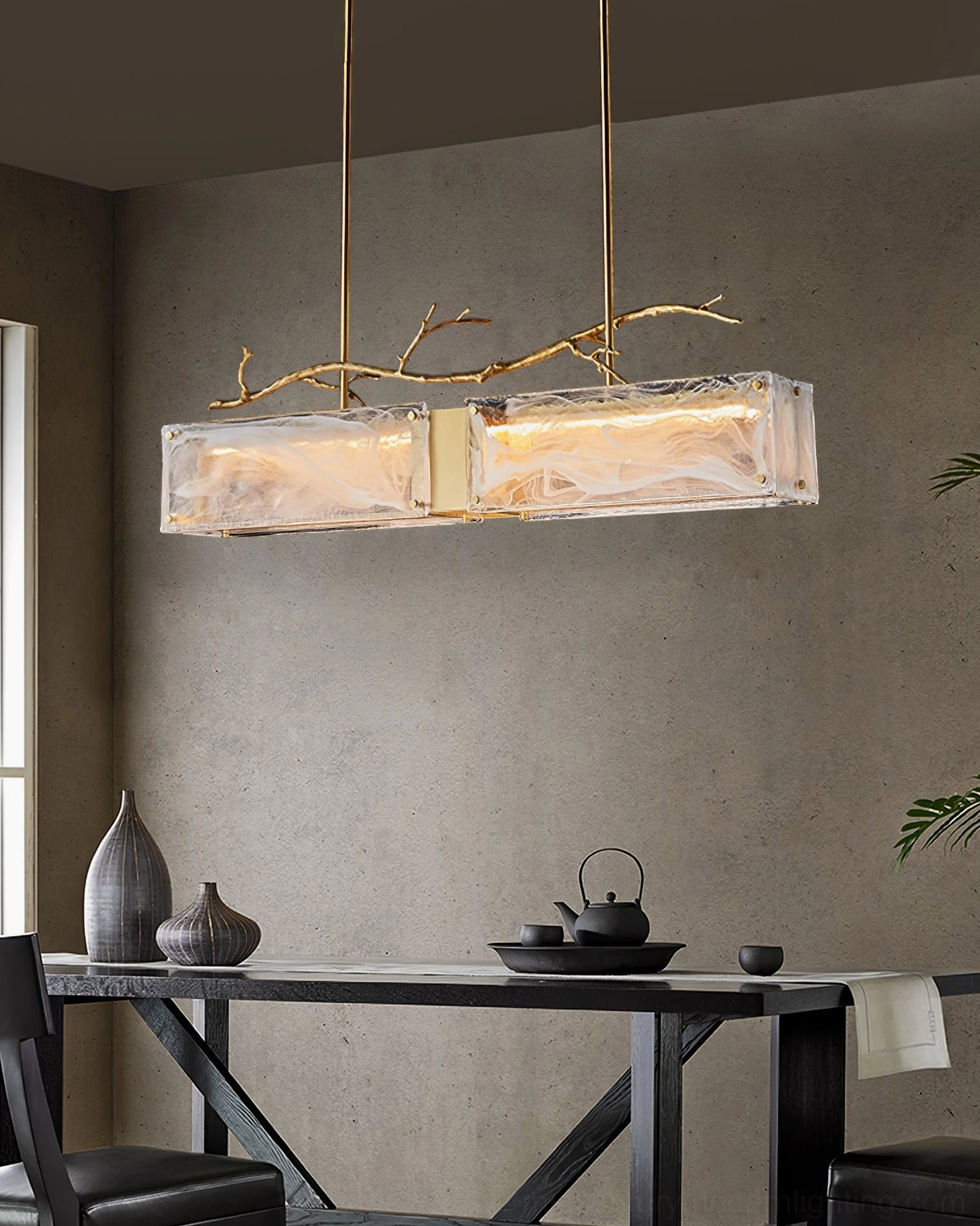 Thalassa brass and glass chandelier showing suspension mechanism and adjustable boom configuration for varied ceiling heights