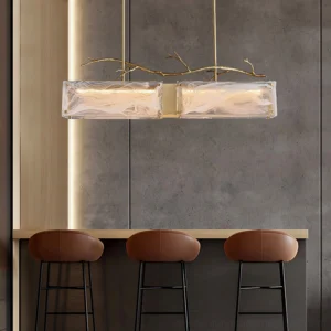 Thalassa chandelier installed in modern bar and dining area with eye-level perspective showing gold brass finish and frosted textured glass