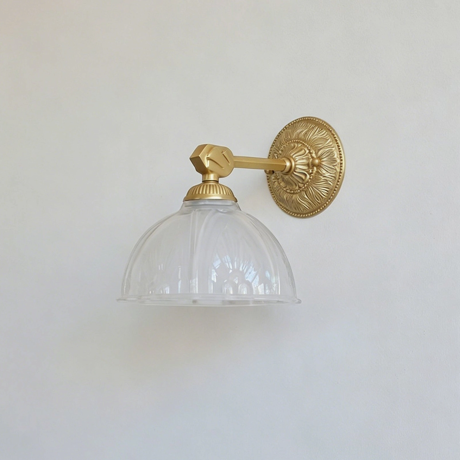 Thayer vintage brass sconce mounted on accent wall beside framed botanical prints and mirror