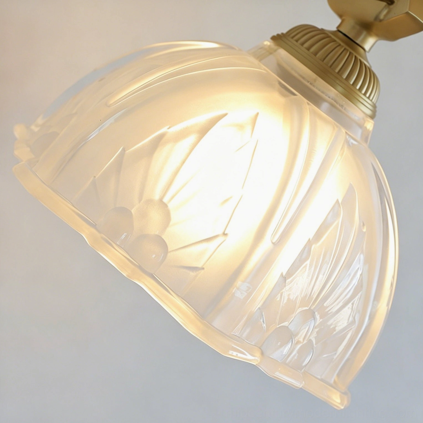Thayer brass wall sconce detail showing brass patina, beaded rim, and clear embossed glass bell