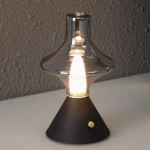 Black matte base Theater lamp with smoked glass shade, three-quarter perspective on textured wall