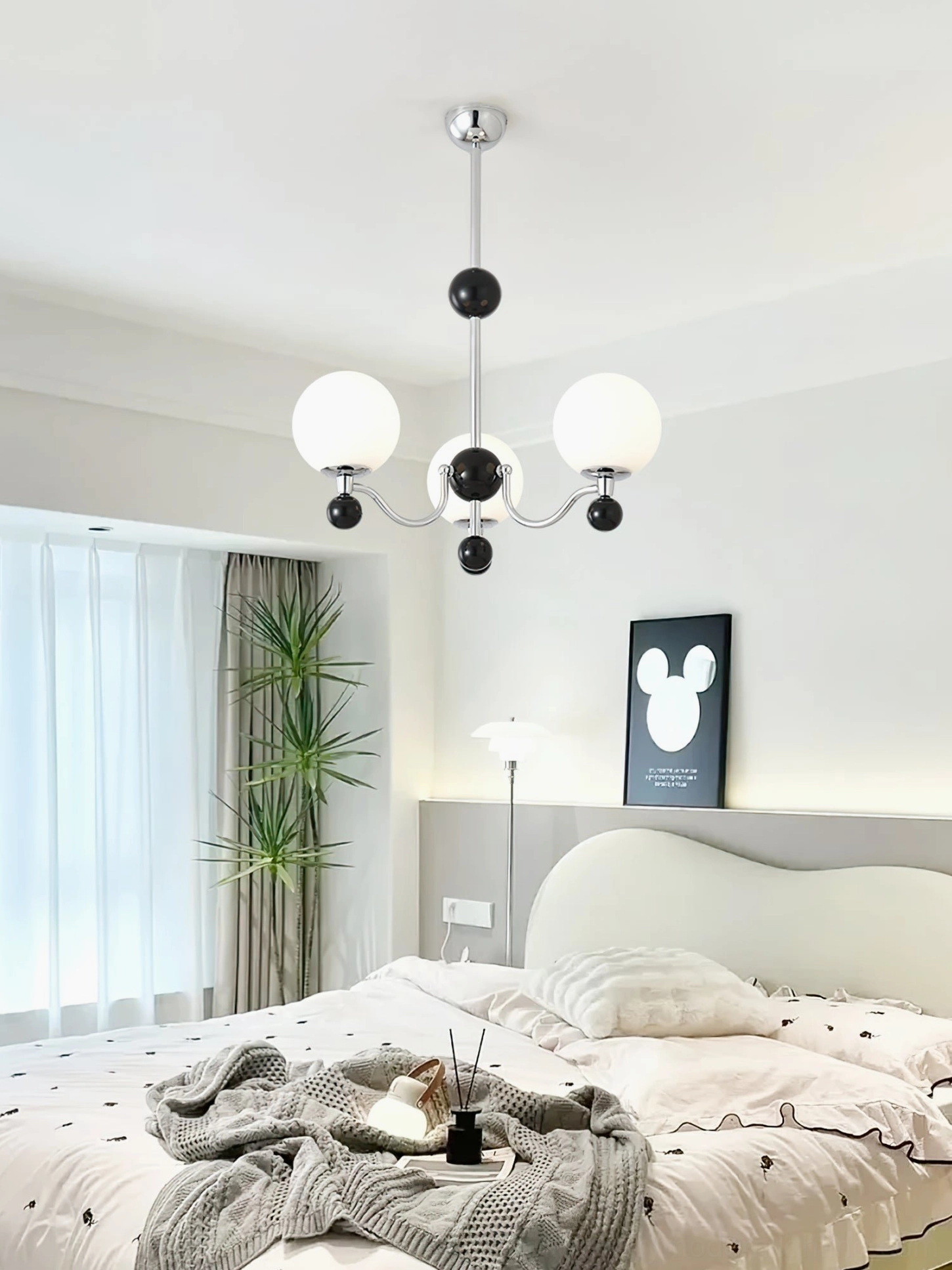 Three-head spherical chrome chandelier in contemporary bedroom with warm neutral tones