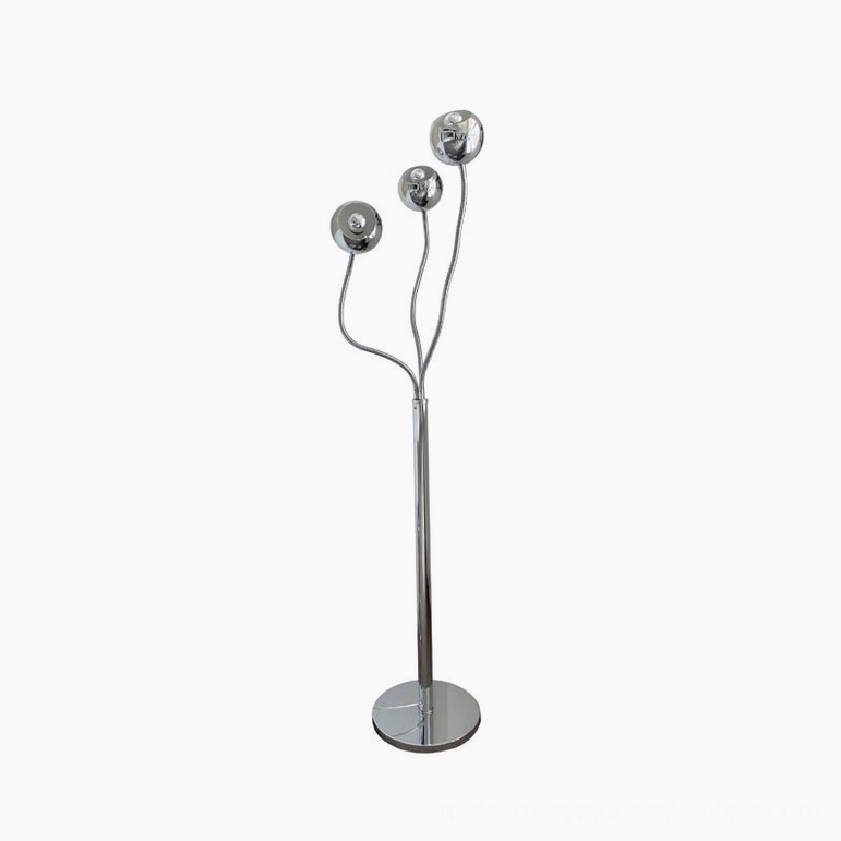 Three-head chrome eyeball floor lamp in minimalist modern interior with neutral tones and contemporary decor